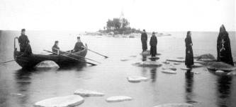Схимник, монахи и послушники на прибрежных камнях Ладожского озера. Остров Коневец. Фото 1900-х